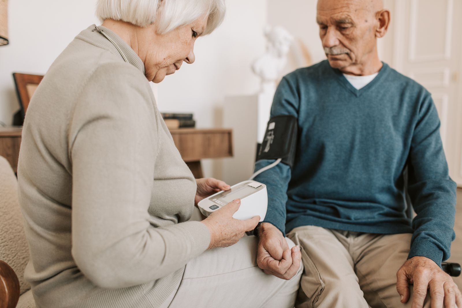 Senior couple checking blood pressure at home
