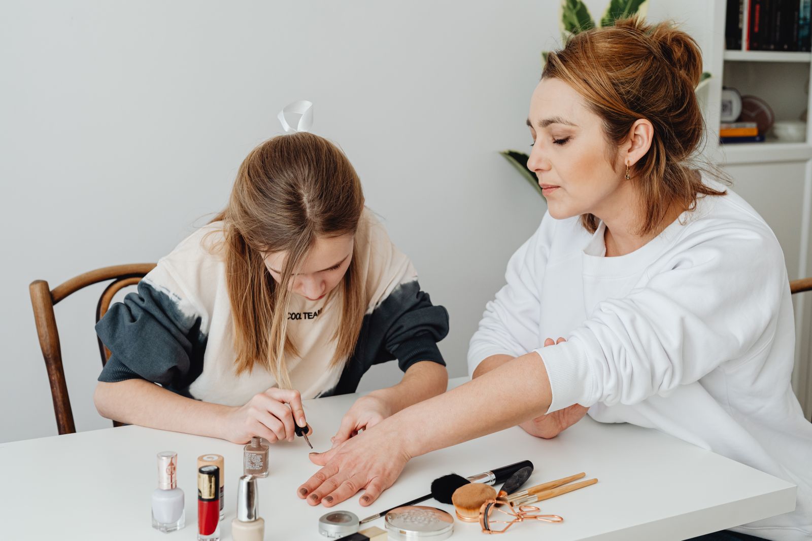 Daughter giving her mother a manicure at home