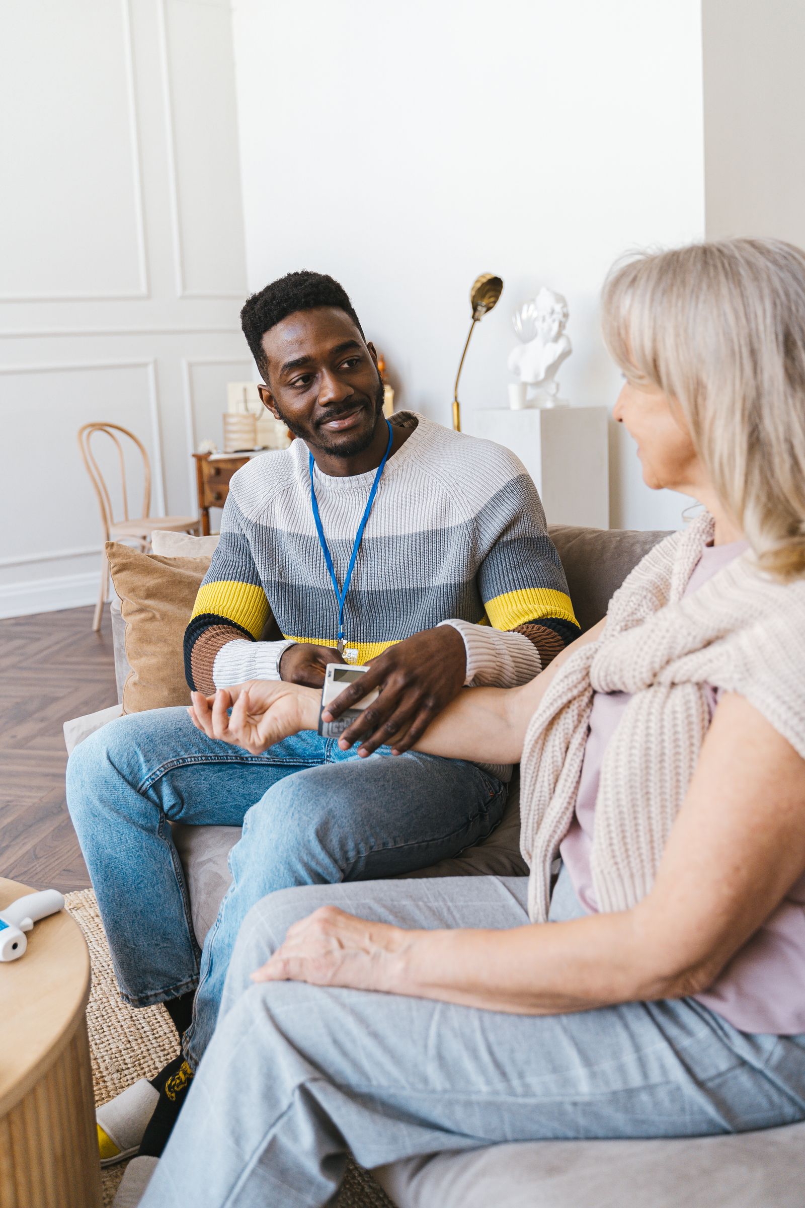 Helping a senior woman with a home blood pressure check