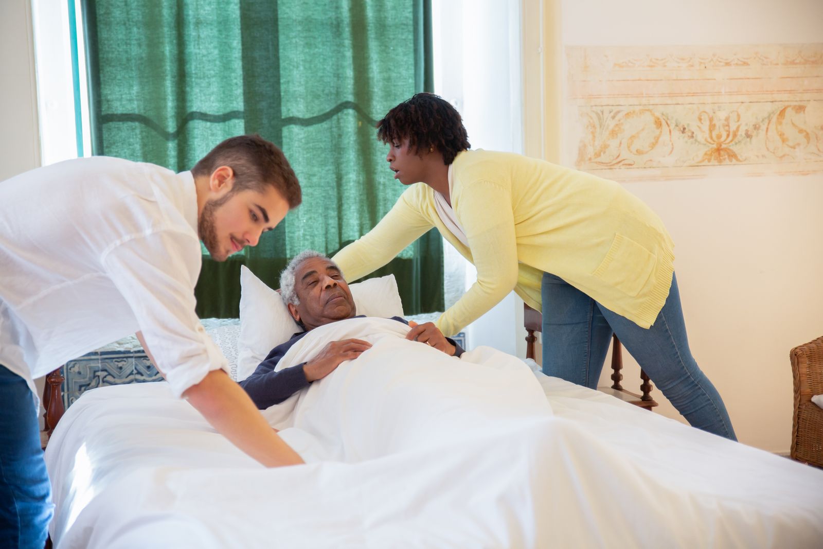Caregivers helping an elderly man at home